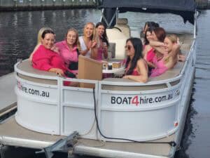 Group of women enjoying a boat ride on a pontoon boat on the water.